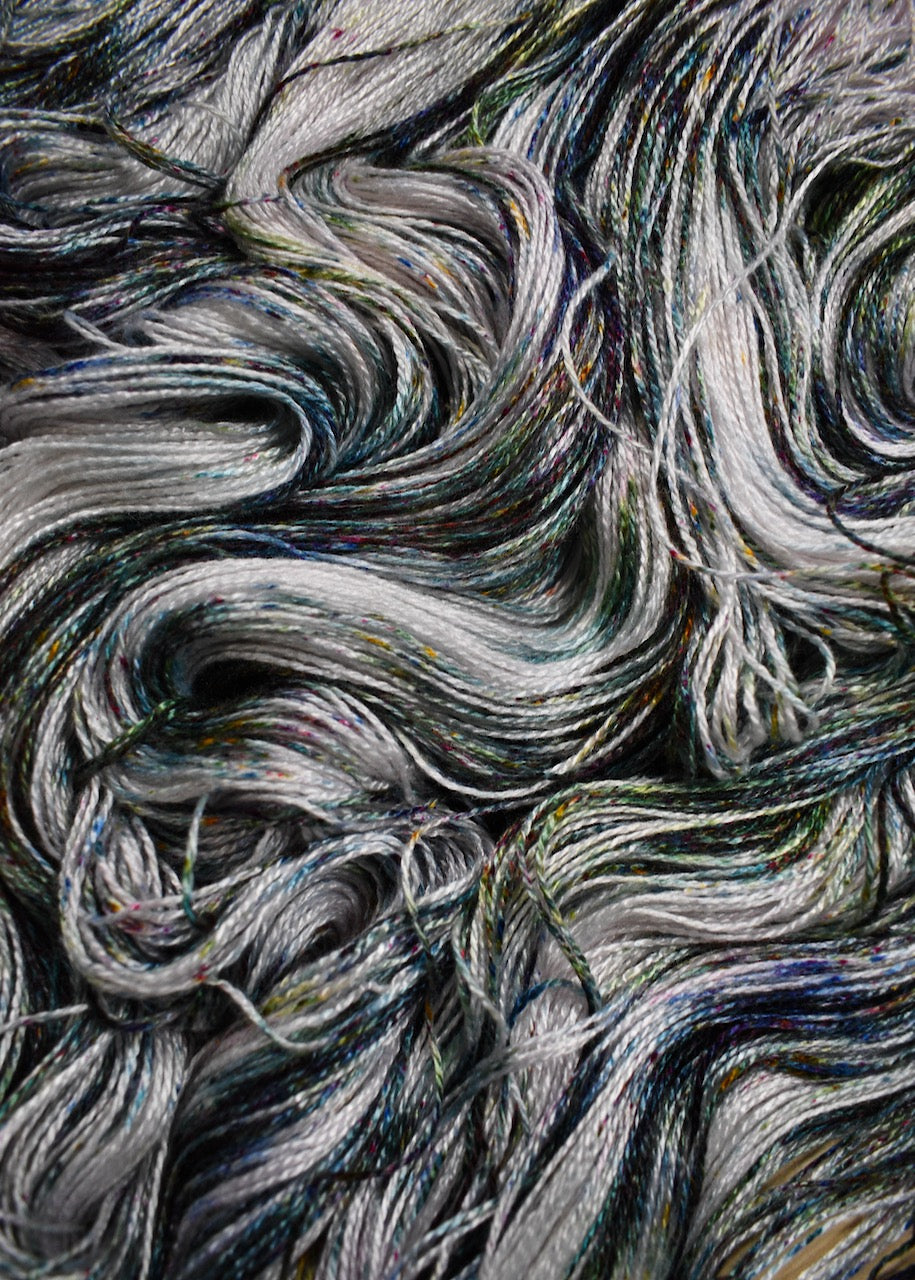 Bamboo sock yarn hand dyed with green speckles.
