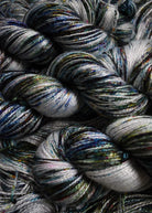 Bamboo sock yarn hand dyed with green speckles.