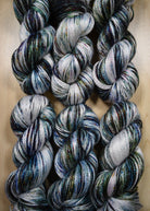 Bamboo sock yarn hand dyed with green speckles.