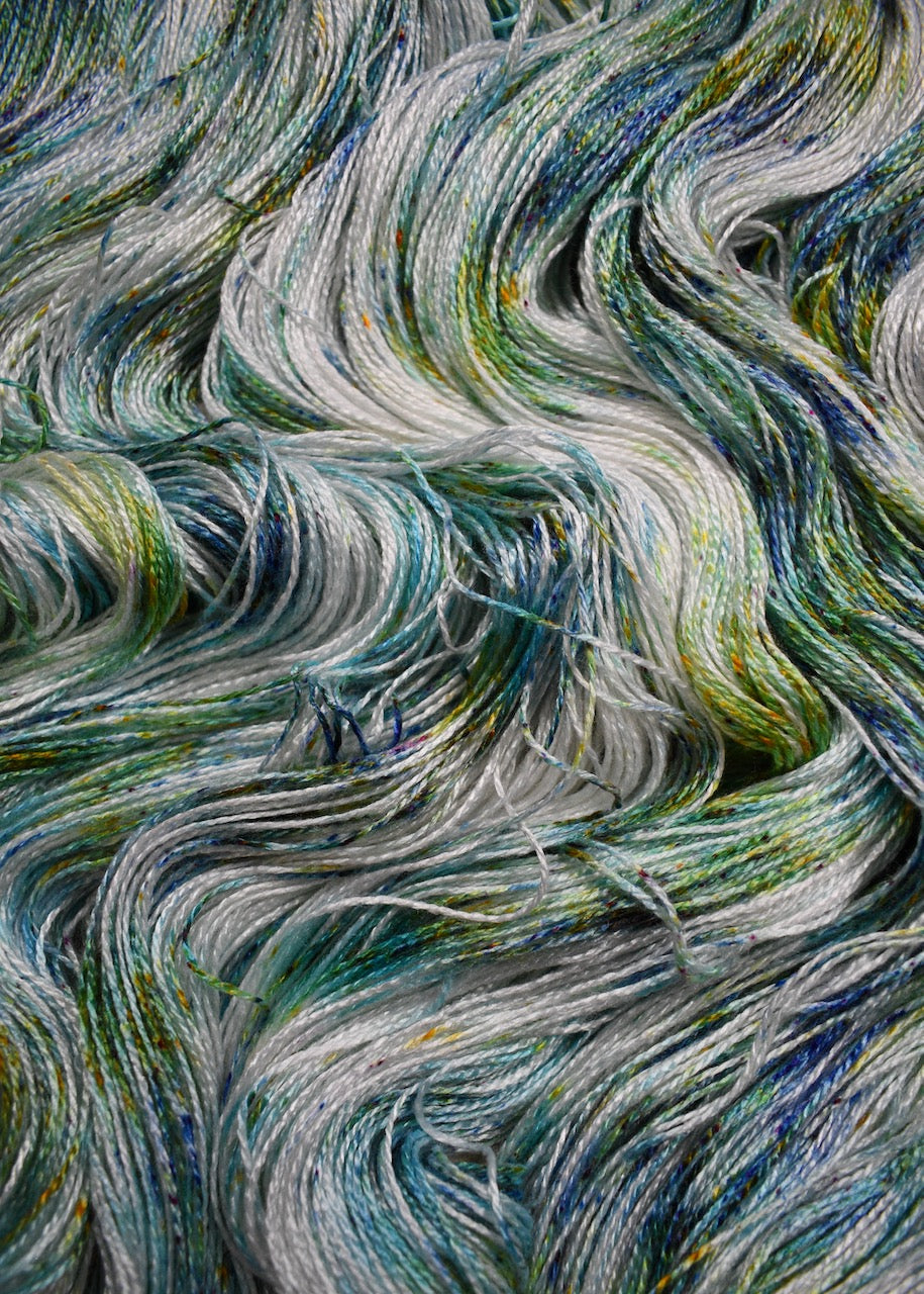 Bamboo sock yarn hand dyed with bright green speckles.