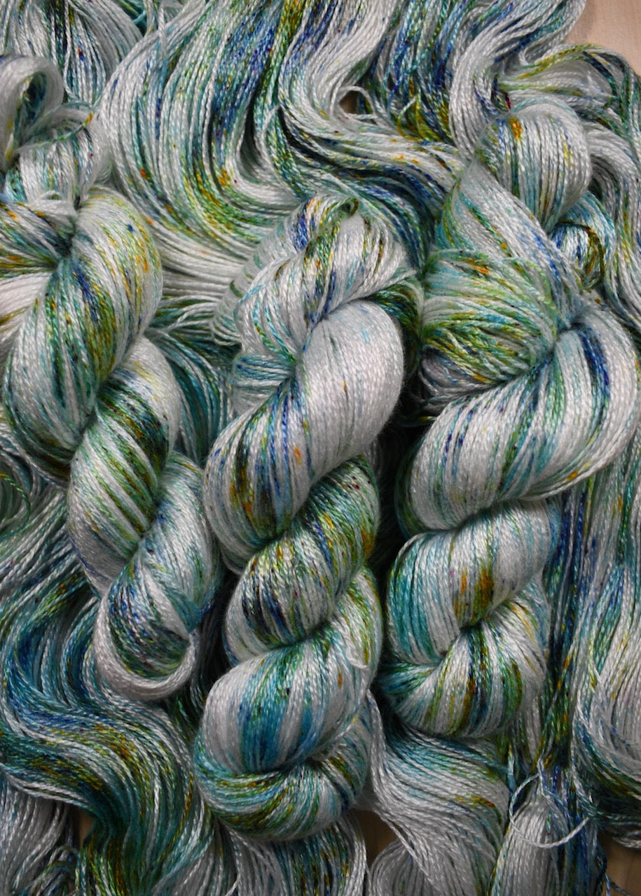 Bamboo sock yarn hand dyed with bright green speckles.