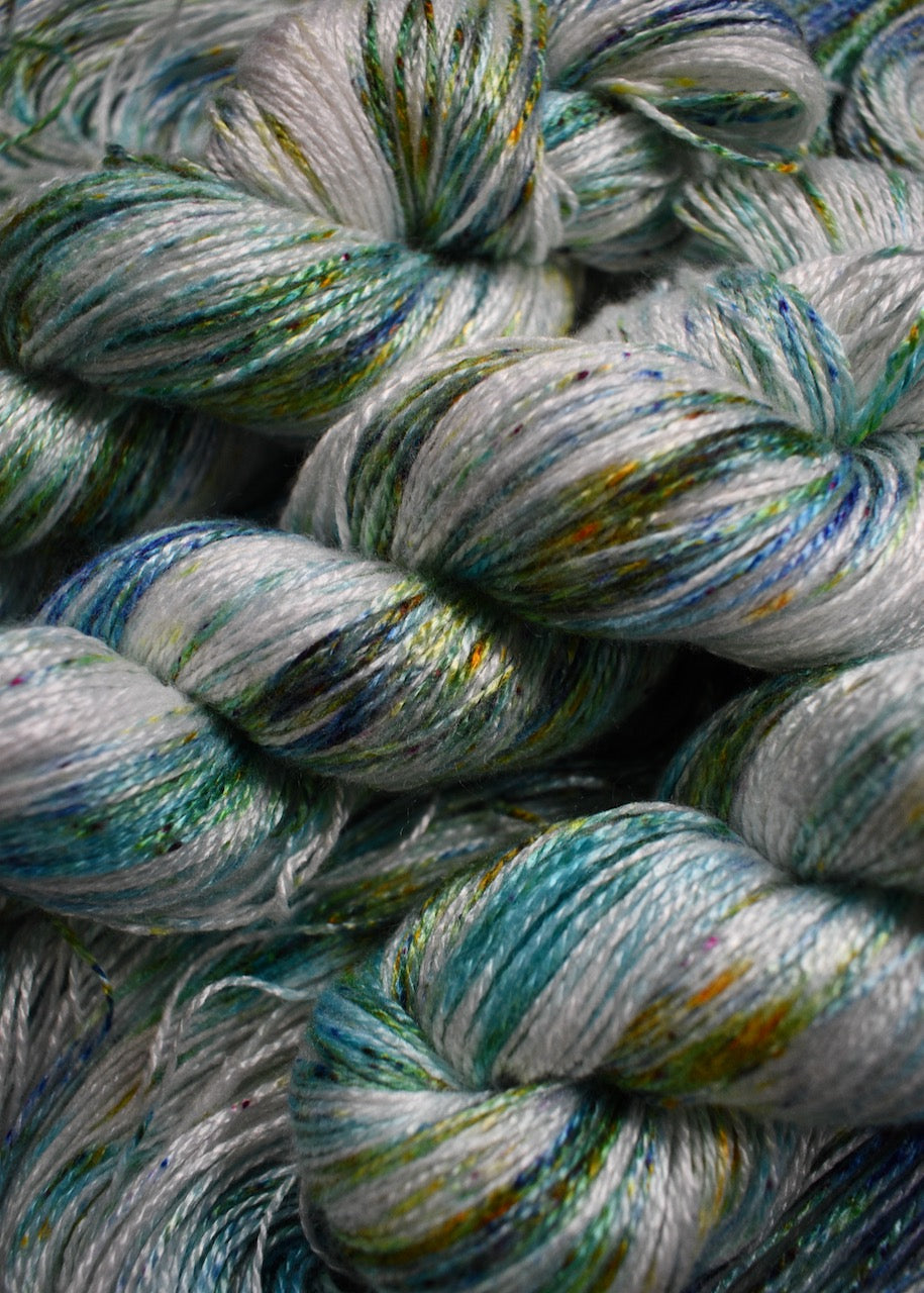 Bamboo sock yarn hand dyed with bright green speckles.