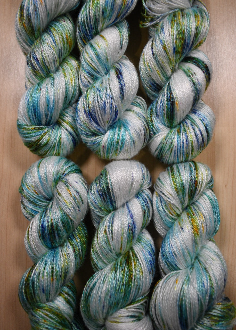 Bamboo sock yarn hand dyed with bright green speckles.