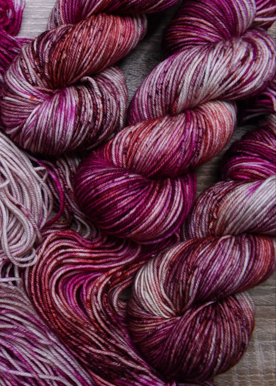 Hand dyed pink speckled merino wool yarn.