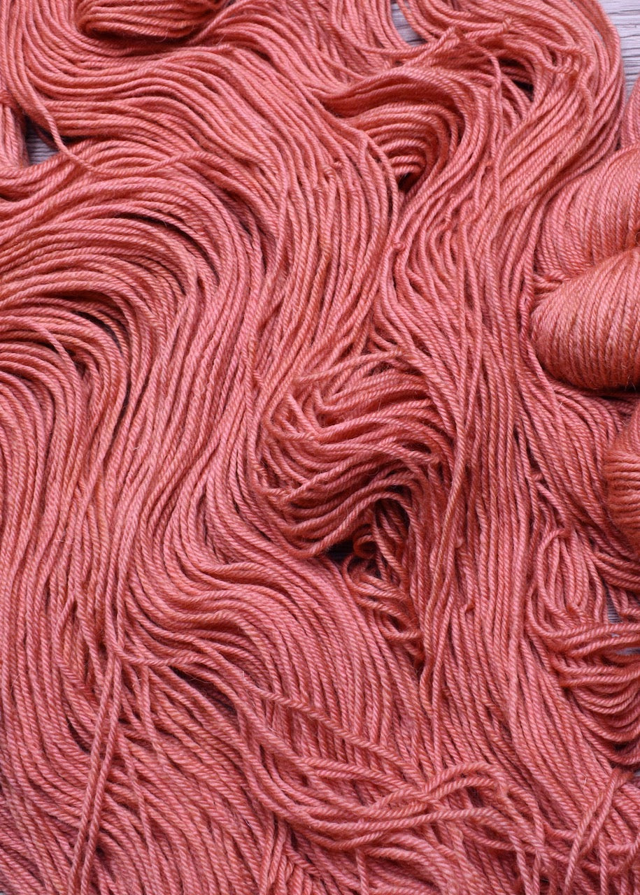 Peach colour hand dyed worsted wool yarn.
