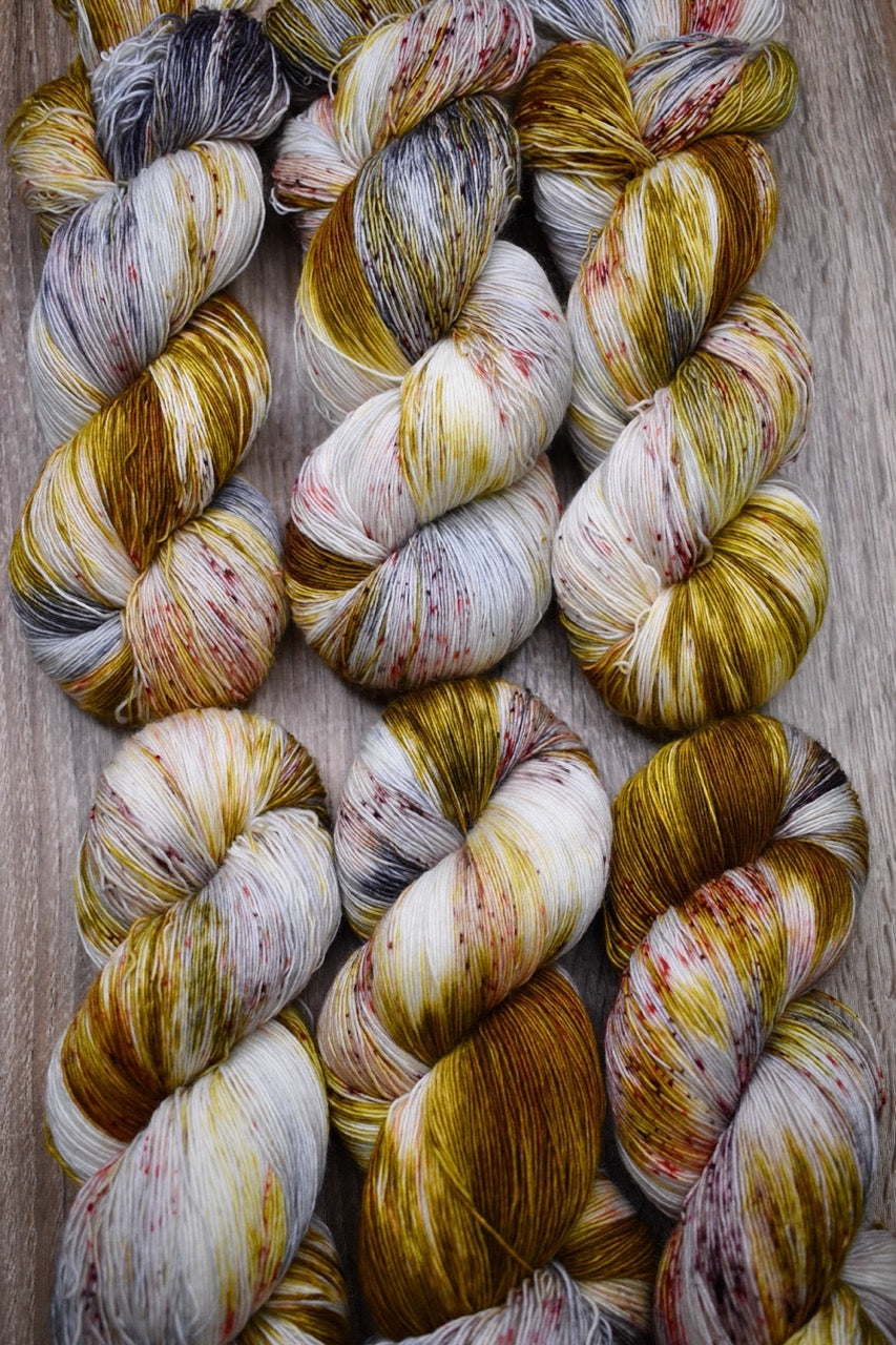 Yellow and brown speckled hand dyed merino lace yarn.