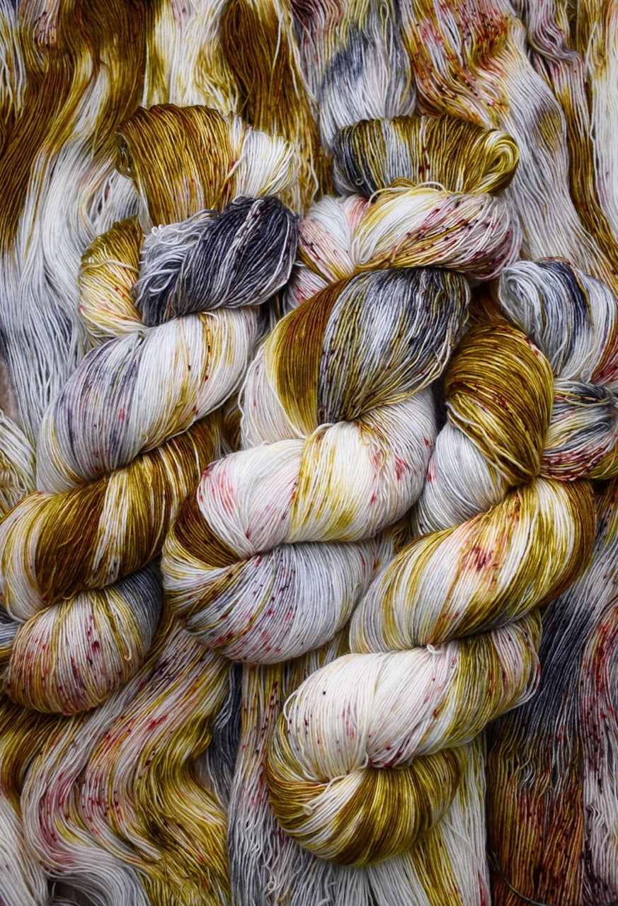 Yellow and brown speckled hand dyed merino lace yarn.