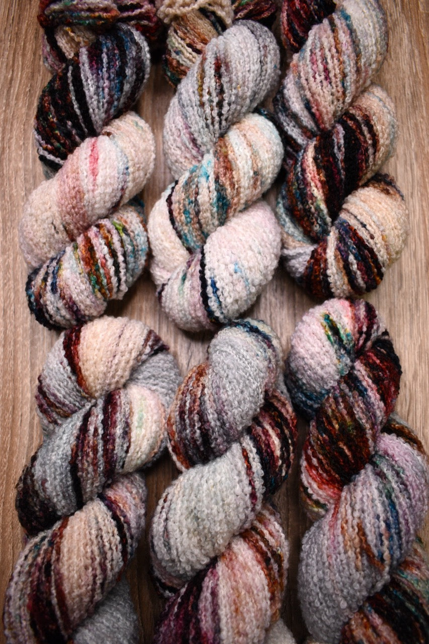 Hand dyed wool boucle yarn in colour African Violet.