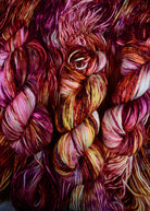 Pink orange yellow speckled hand dyed merino worsted yarn.