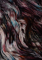 Hand dyed wool sock yarn with blue and red speckles.