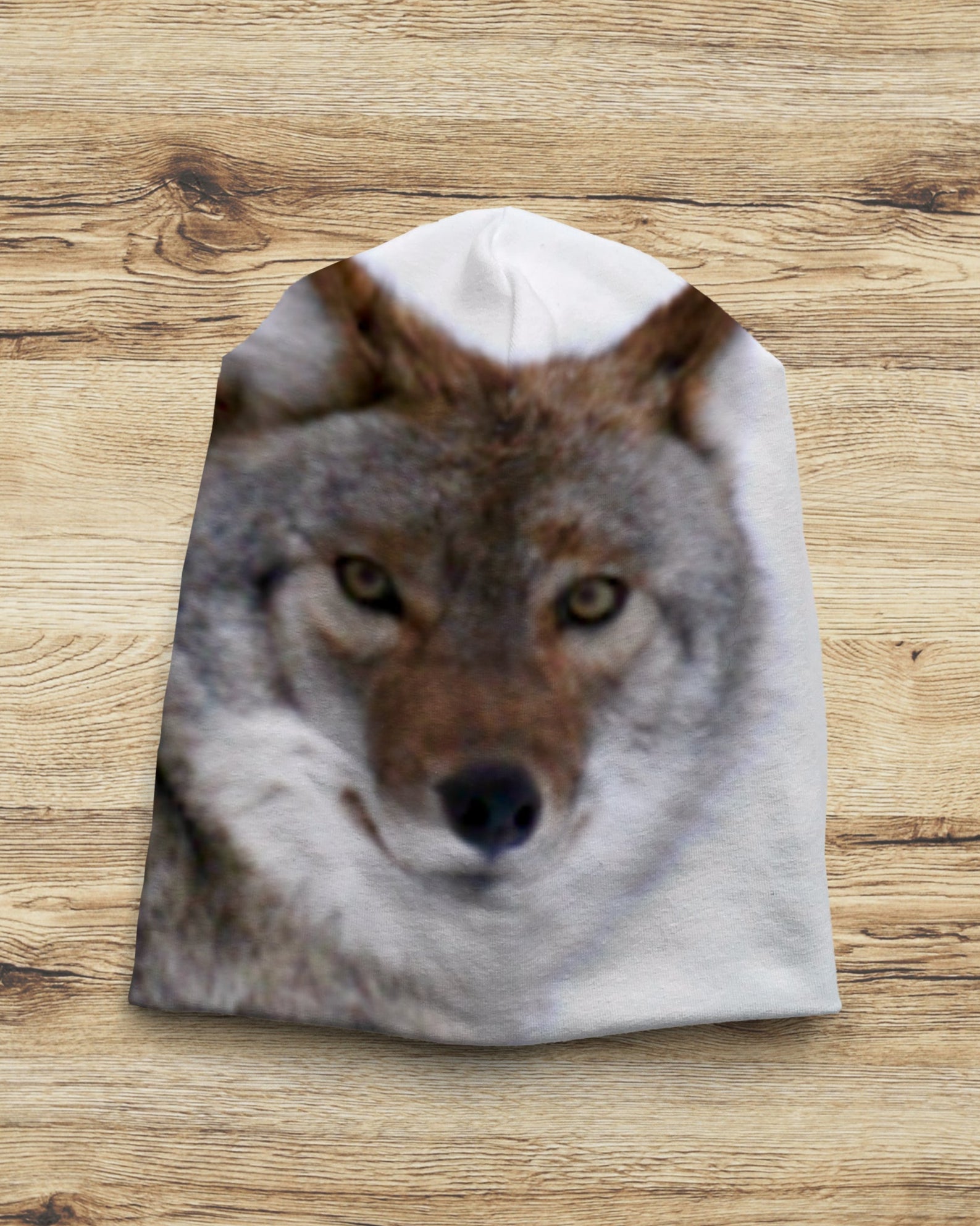Slouchy Beanie with a wolf design on a wooden surface