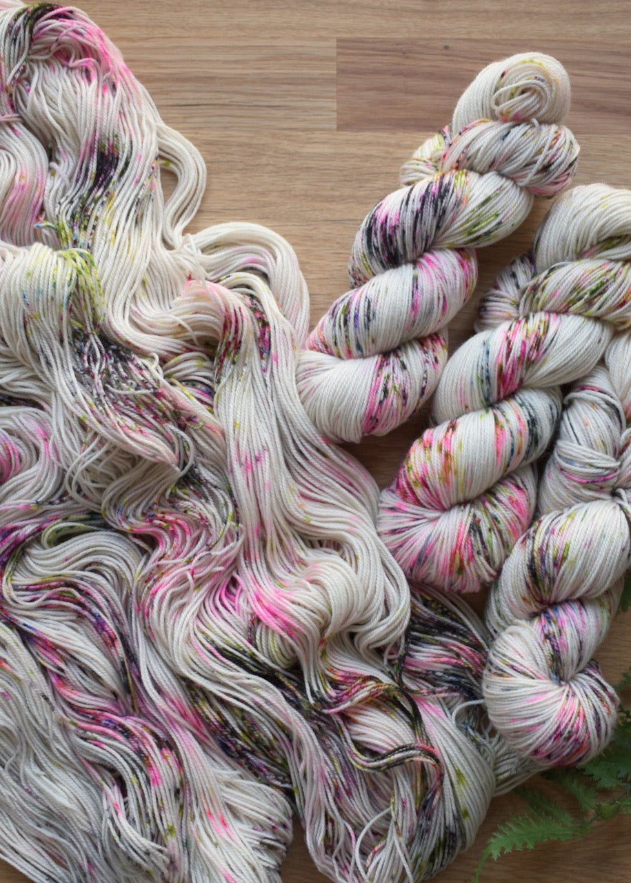 Bright pink and black speckled merino cashmere hand dyed sock yarn.