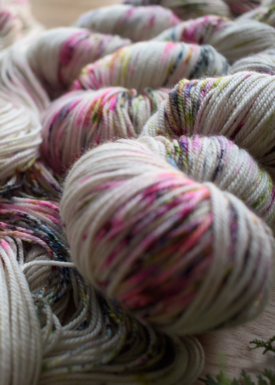 Bright pink and black speckled merino cashmere hand dyed sock yarn.