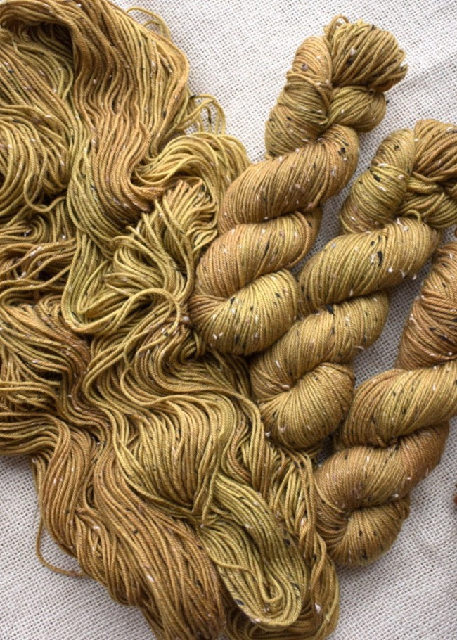 Hand dyed yellow merino wool tweed yarn.
