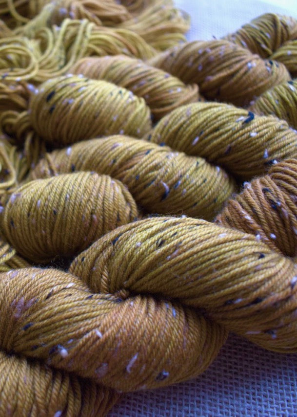 Hand dyed yellow merino wool tweed yarn.