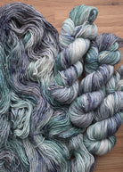 Gray and soft green speckled hand dyed merino yarn.