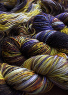 Purple and yellow hand dyed merino sport weight yarn.