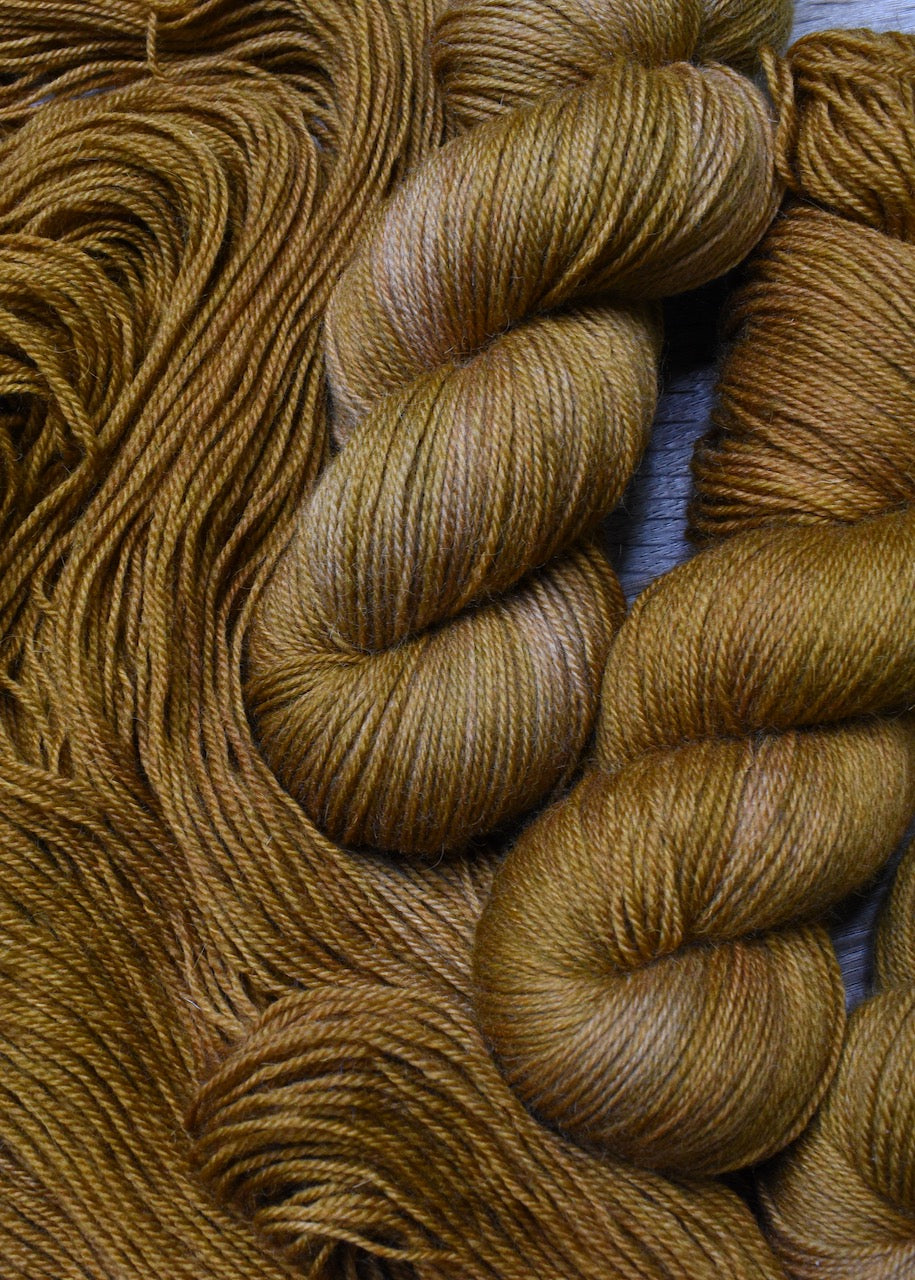 Golden brown hand dyed merino sock yarn.