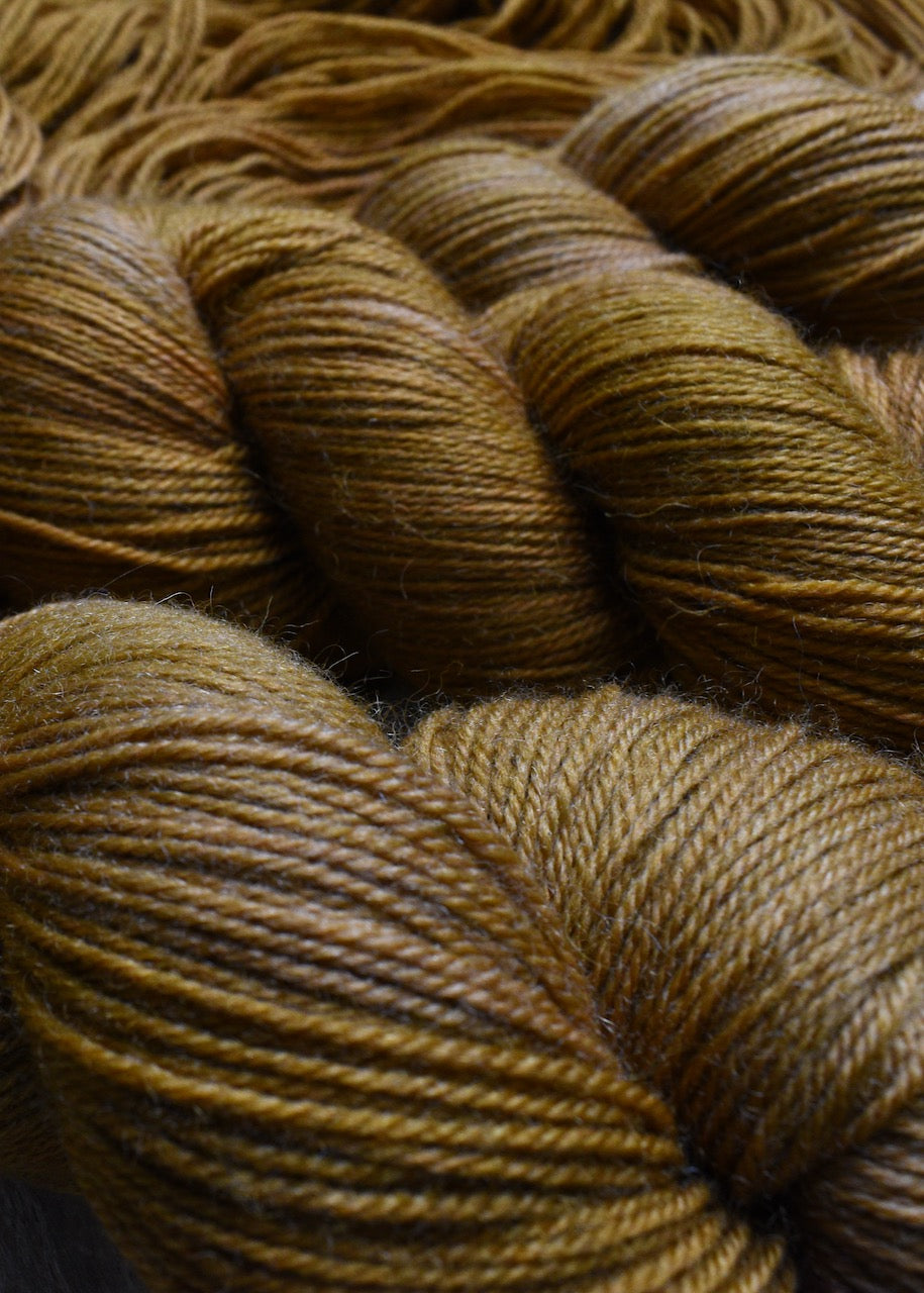 Golden brown hand dyed merino sock yarn.