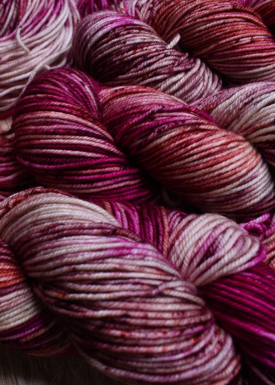 Hand dyed pink speckled merino wool yarn.