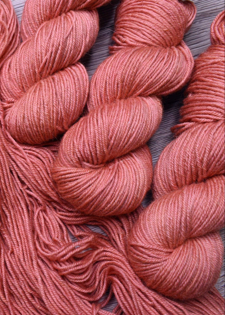 Peach colour hand dyed worsted wool yarn.