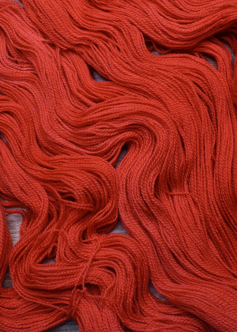 Red hand dyed wool sock yarn.