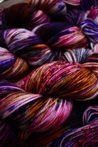  Hand dyed merino sport yarn red, purple and brown speckled.