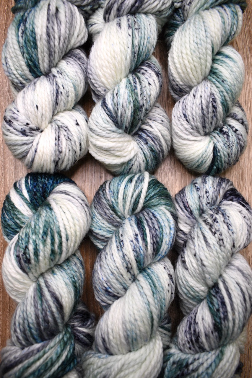 Gray light green speckled hand dyed bulky merino yarn.