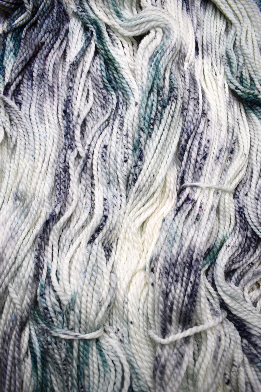Gray light green speckled hand dyed bulky merino yarn.