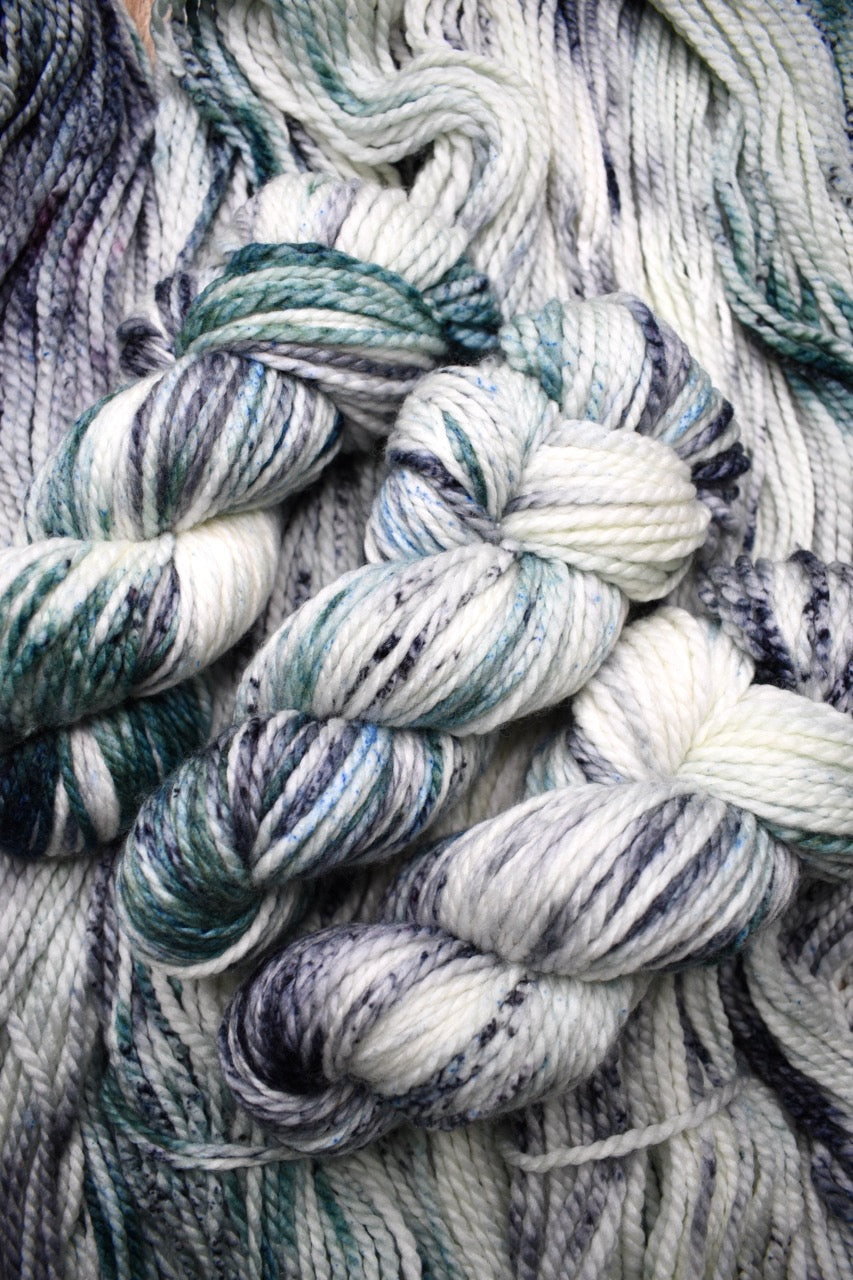Gray light green speckled hand dyed bulky merino yarn.