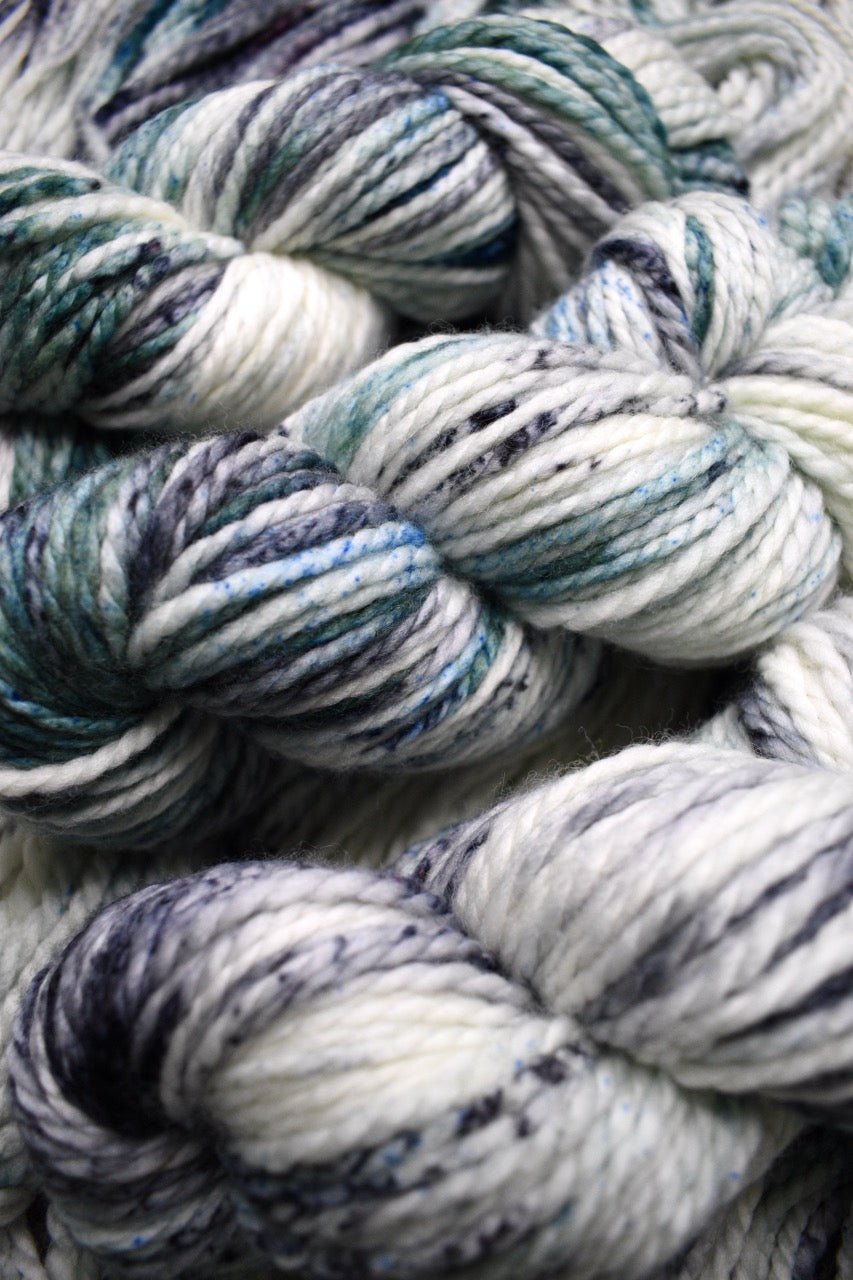 Gray light green speckled hand dyed bulky merino yarn.