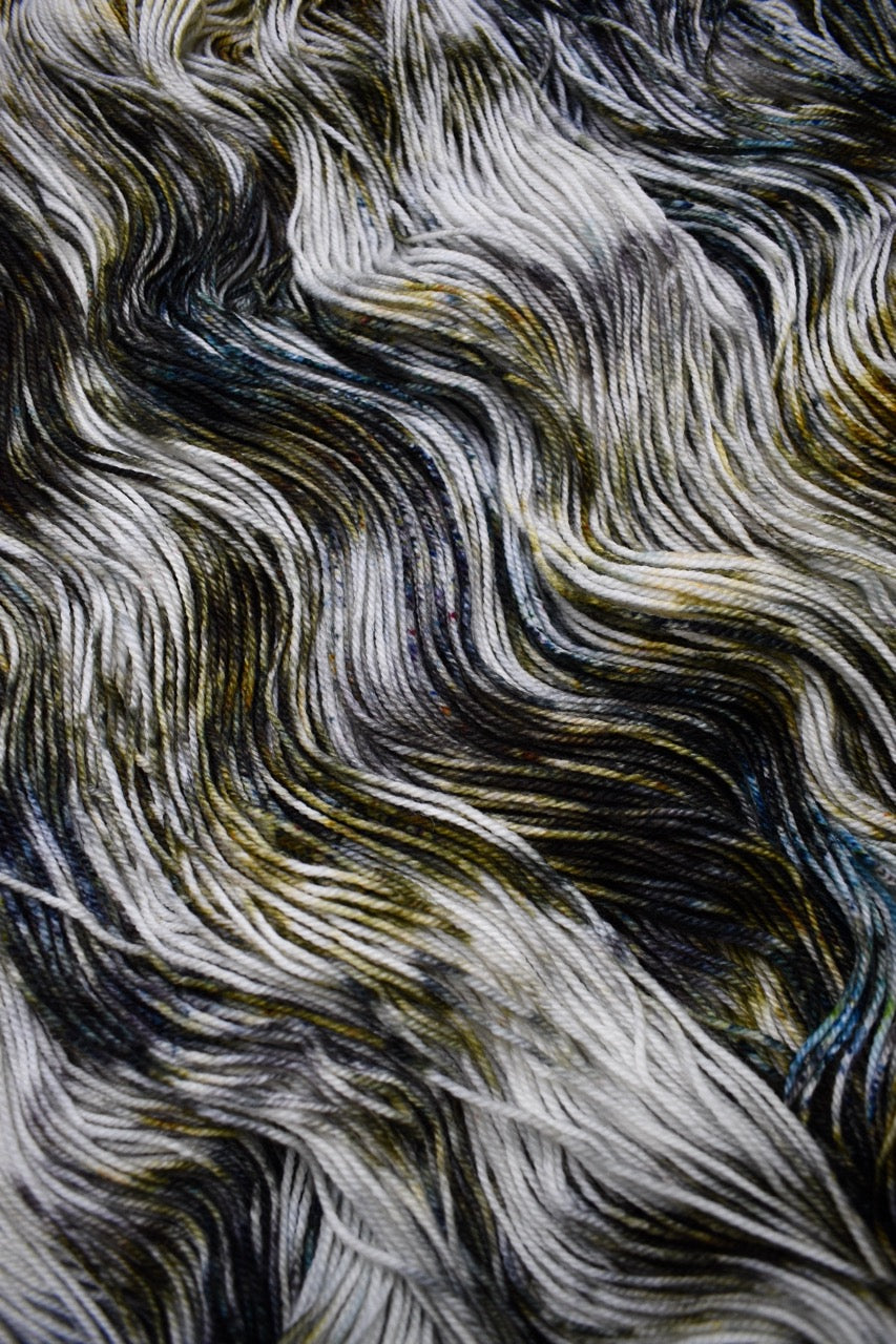 Green and brown speckled hand dyed merino sock yarn.