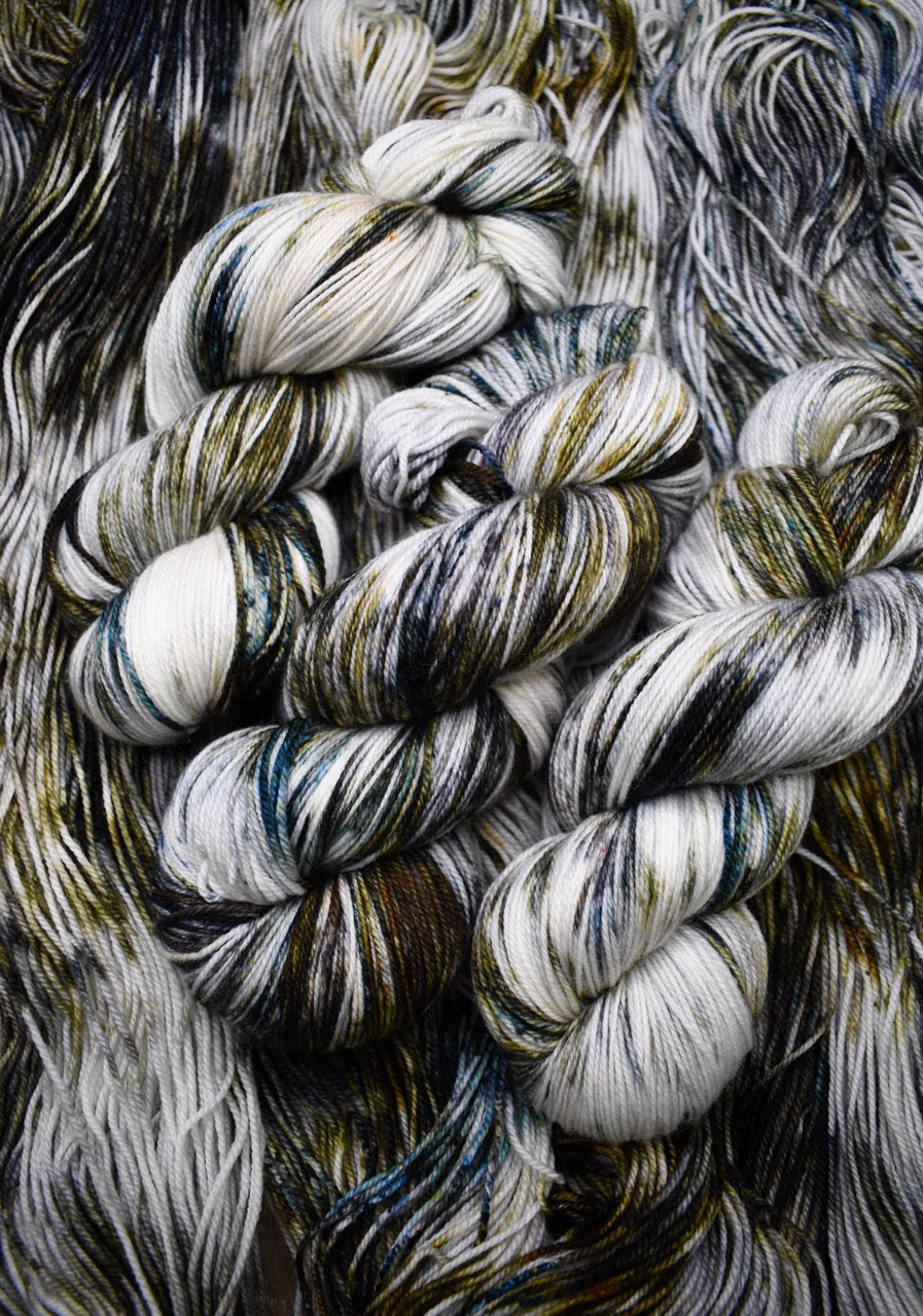 Green and brown speckled hand dyed merino sock yarn.