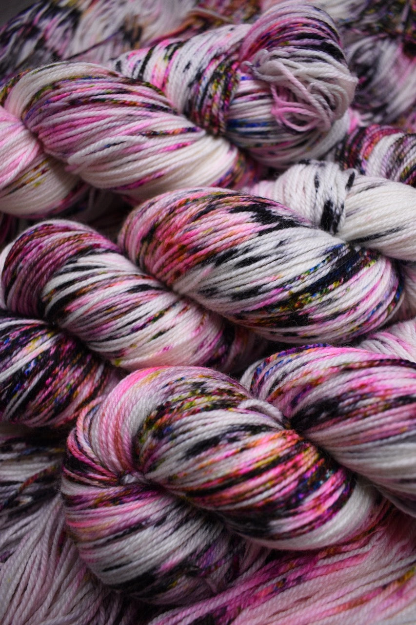 Pink speckled hand dyed merino sock yarn.