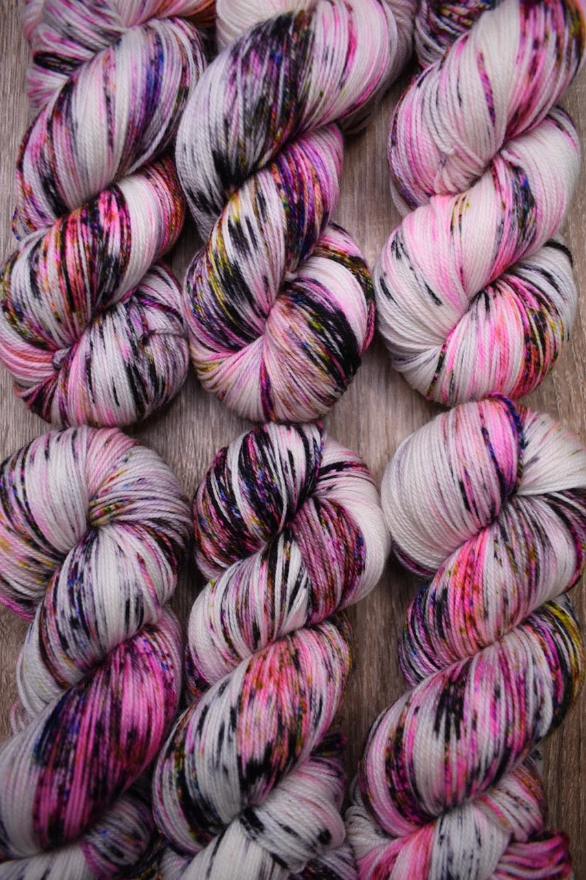 Pink speckled hand dyed merino sock yarn.