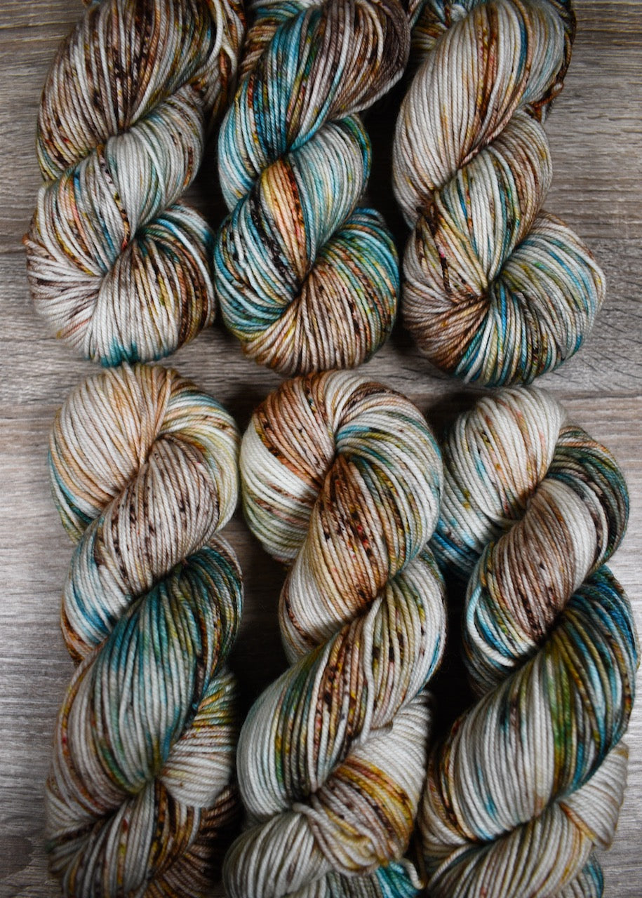 Blue and brown speckled hand dyed merino worsted yarn.