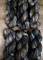 Gray blue purple speckled hand dyed merino worsted yarn.