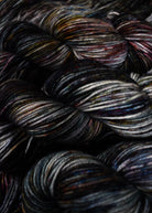 Gray blue purple speckled hand dyed merino worsted yarn.