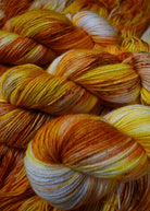 Yellow speckled hand dyed wool sock yarn.