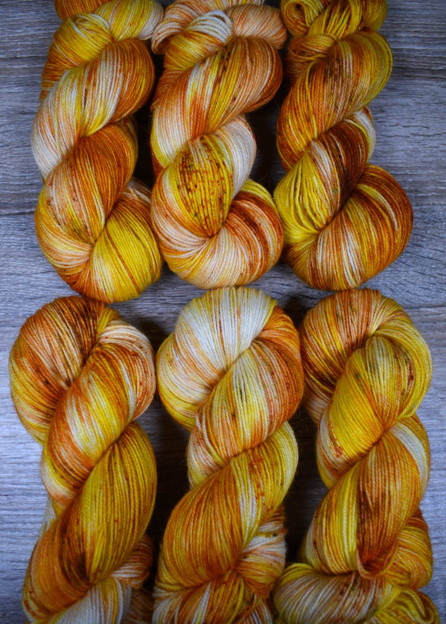 Yellow speckled hand dyed wool sock yarn.