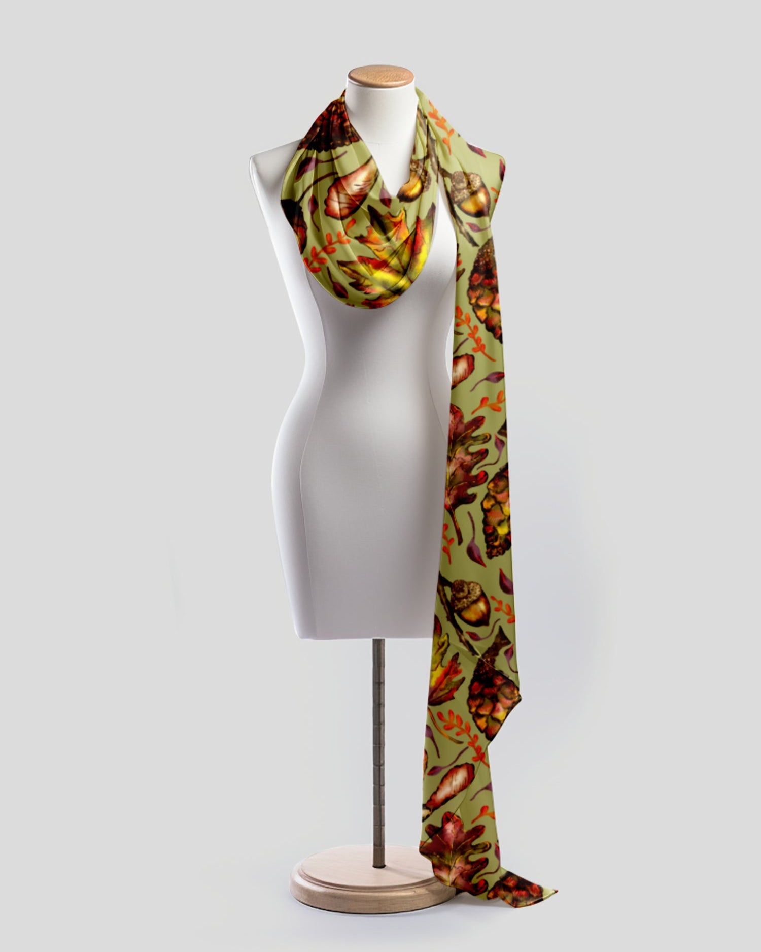 Scarf with autumn leaf pattern on a mannequin against a white background