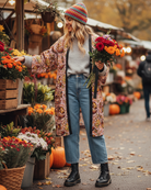 Woman shopping at an outdoor market with flowers and pumpkins
