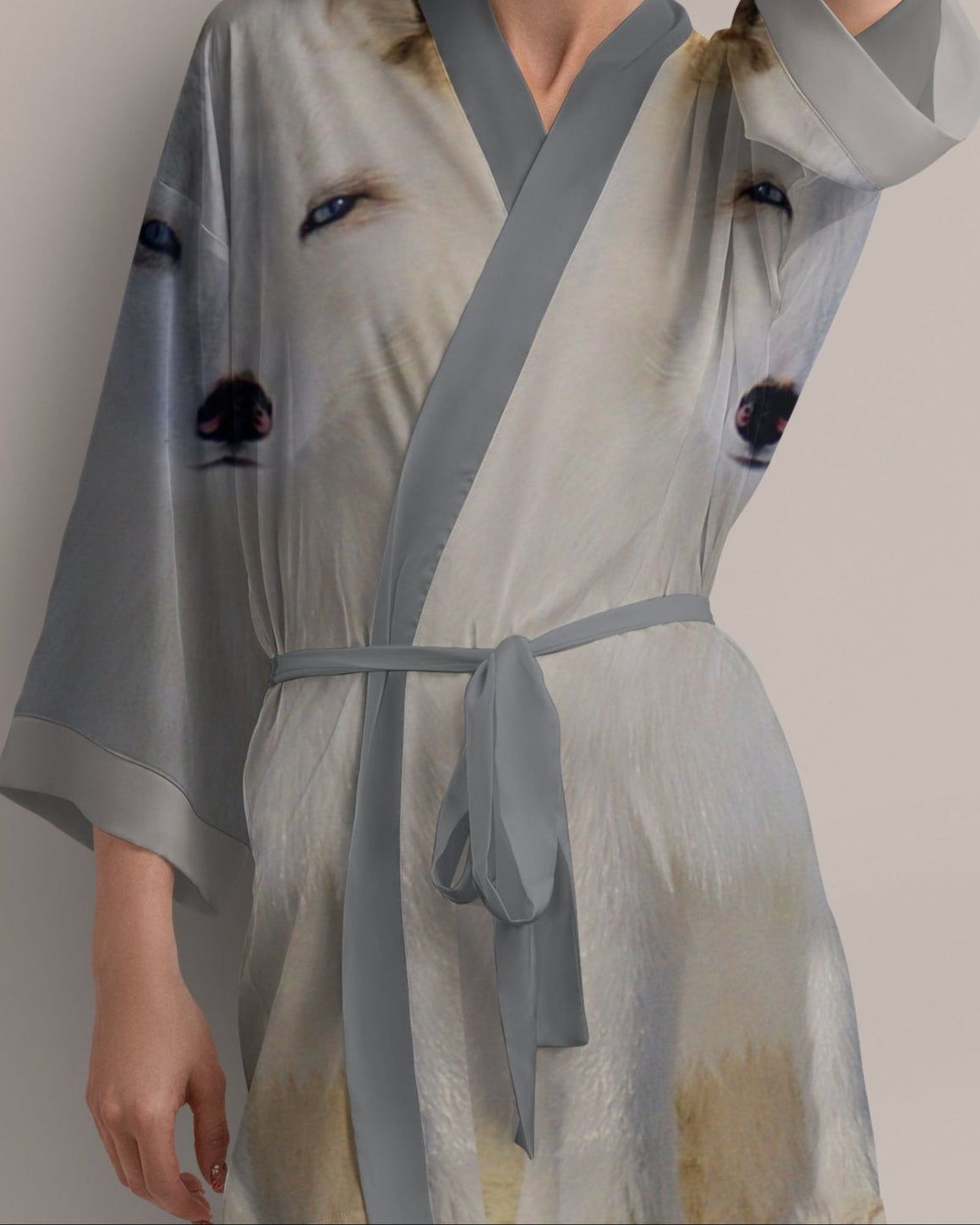 Woman wearing a light gray robe with black arctic fox print on a plain background