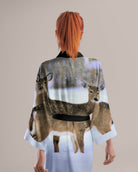Woman wearing a kimono with deer print on a plain background