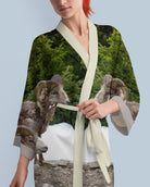 Woman wearing a kimono-style garment with a nature-themed design featuring animals.