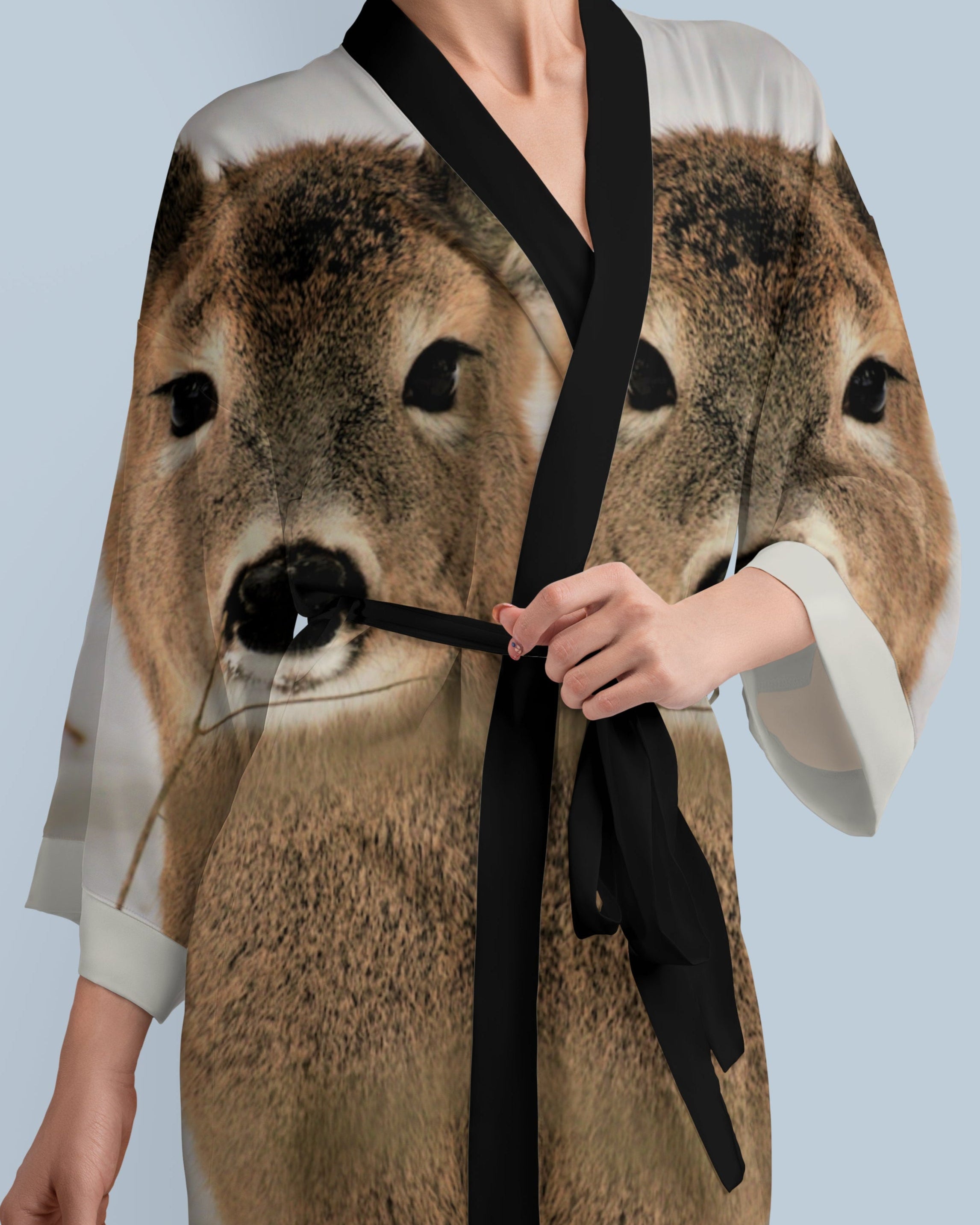 Woman wearing a dress with a deer print against a light blue background