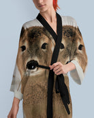 Woman wearing a dress with a deer print against a light blue background