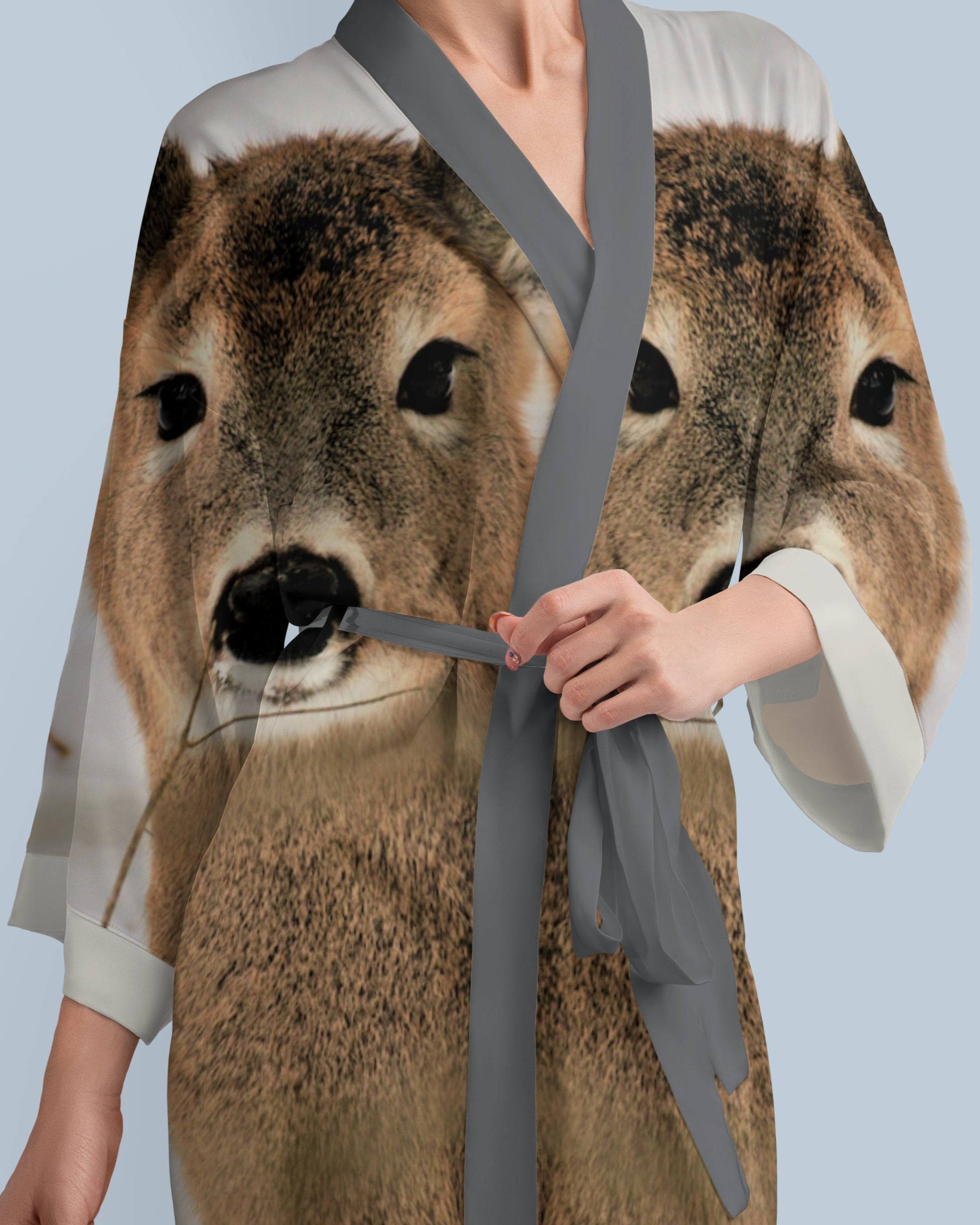 Person wearing a robe with a deer print on a light blue background