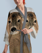 Person wearing a robe with a deer print on a light blue background