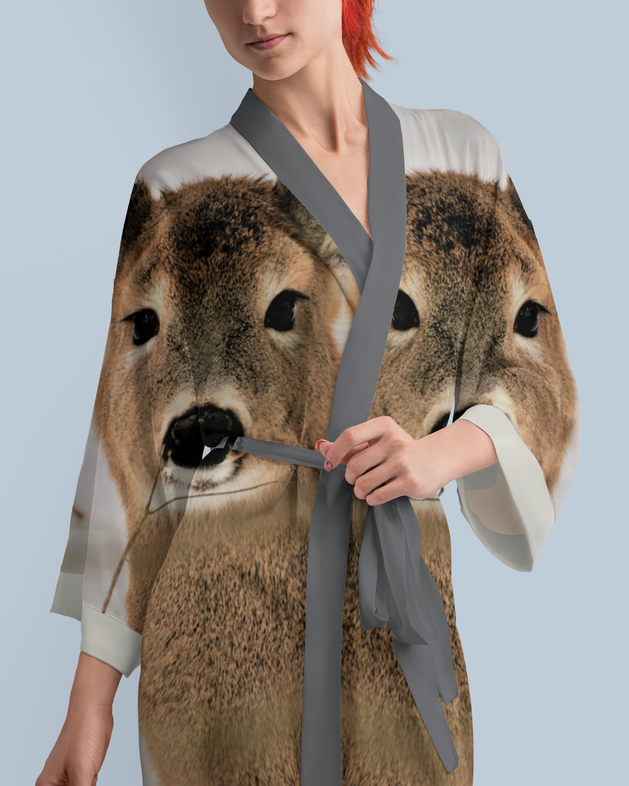 Person wearing a robe with a deer print on a light blue background
